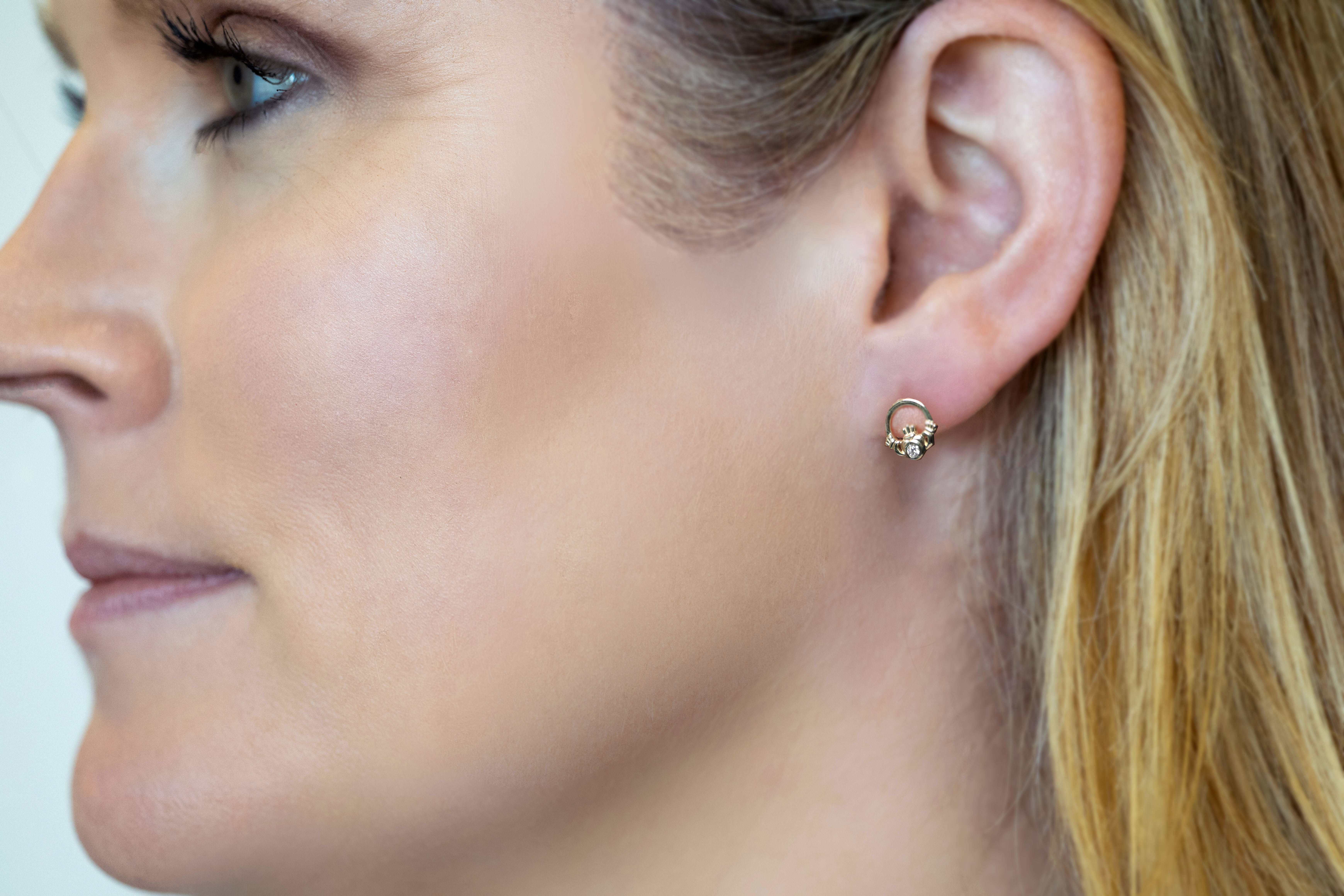 Womens Claddagh Earrings in Yellow Gold With a Polished Finish - Model Photo