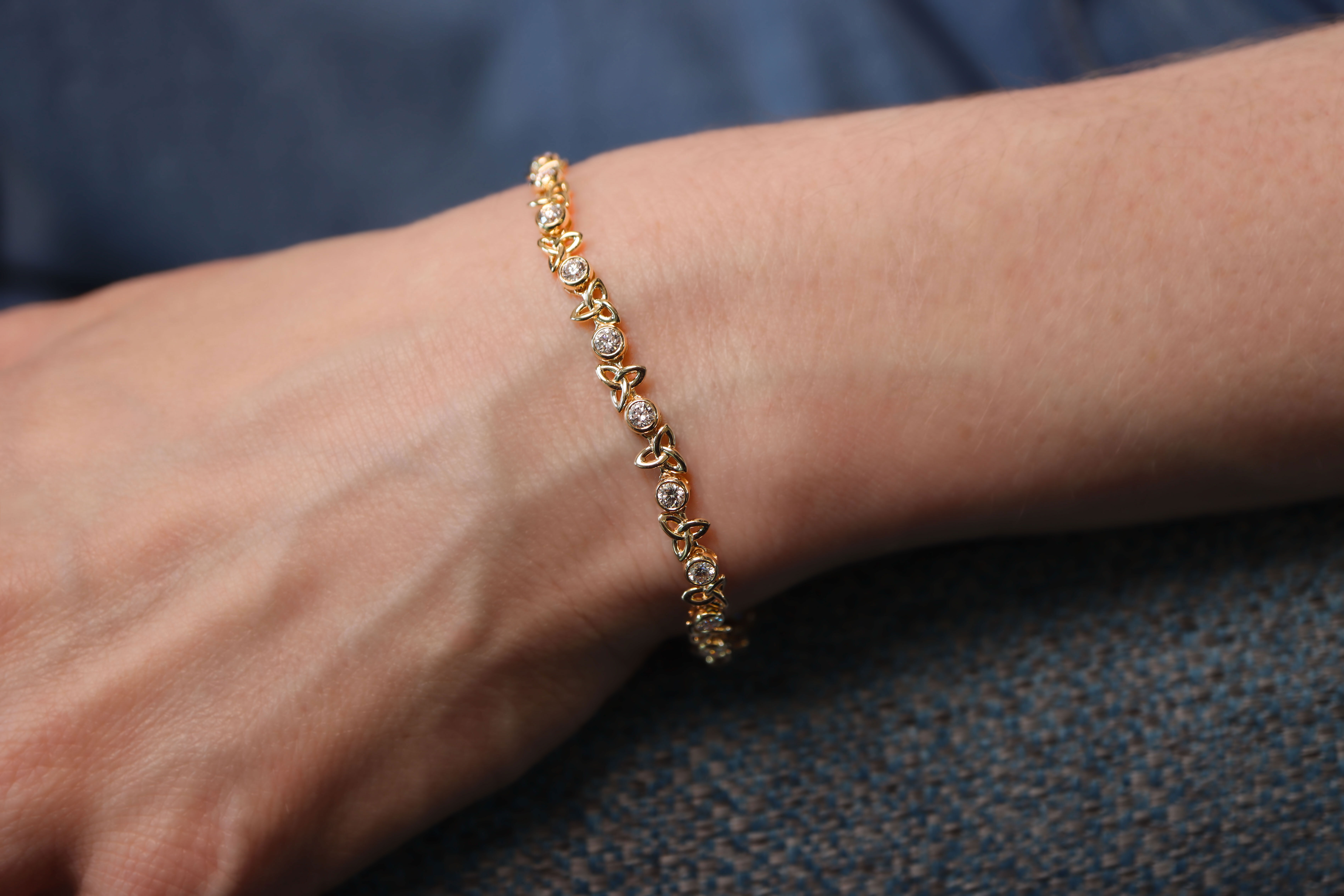 Womens Trinity Knot Bracelet in 14K Yellow Gold With a Polished Finish - Model Photo