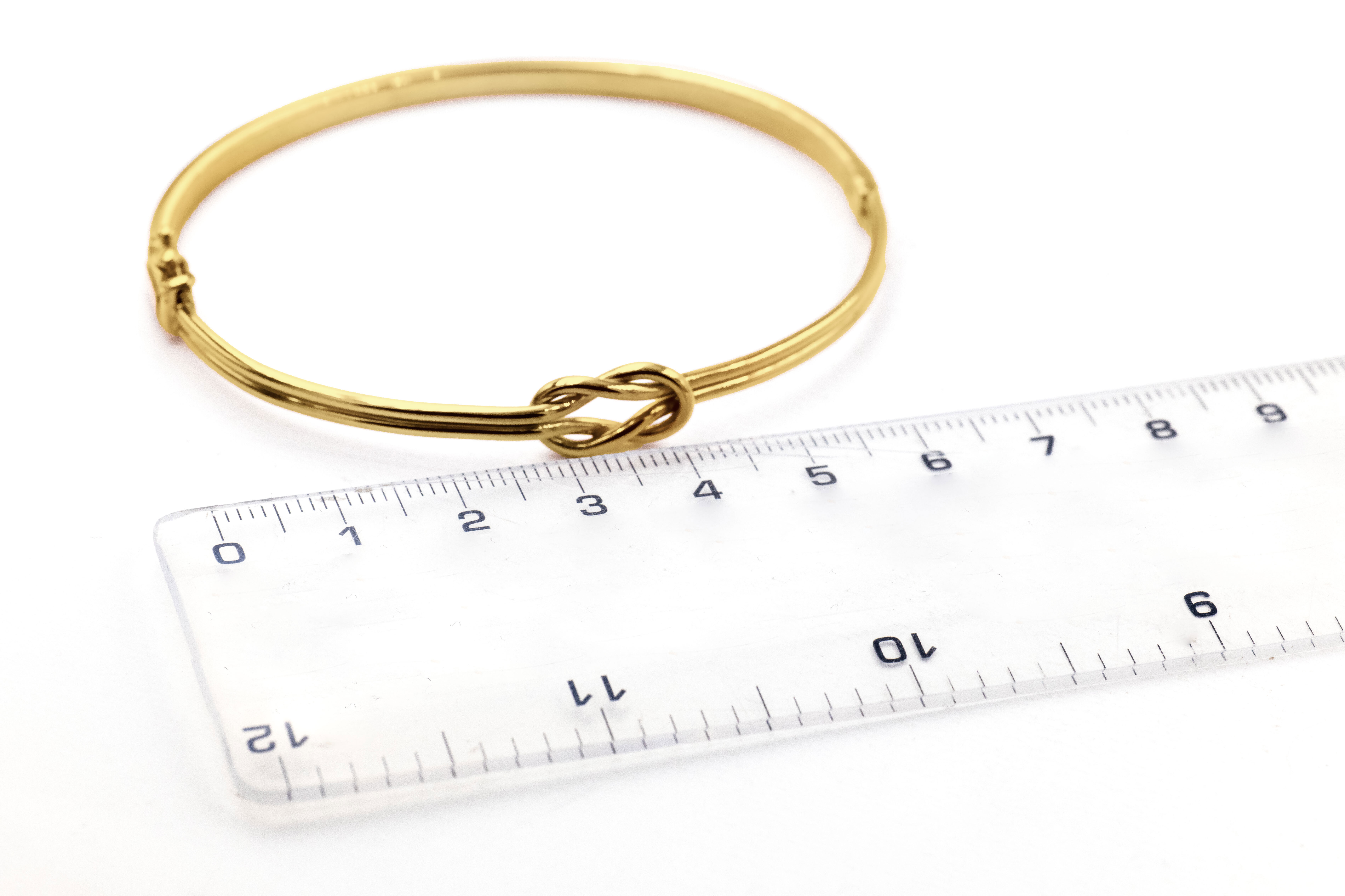 Genuine Yellow Gold Celtic Knot Bracelet For Women With a Polished Finish. Picture For Scale.