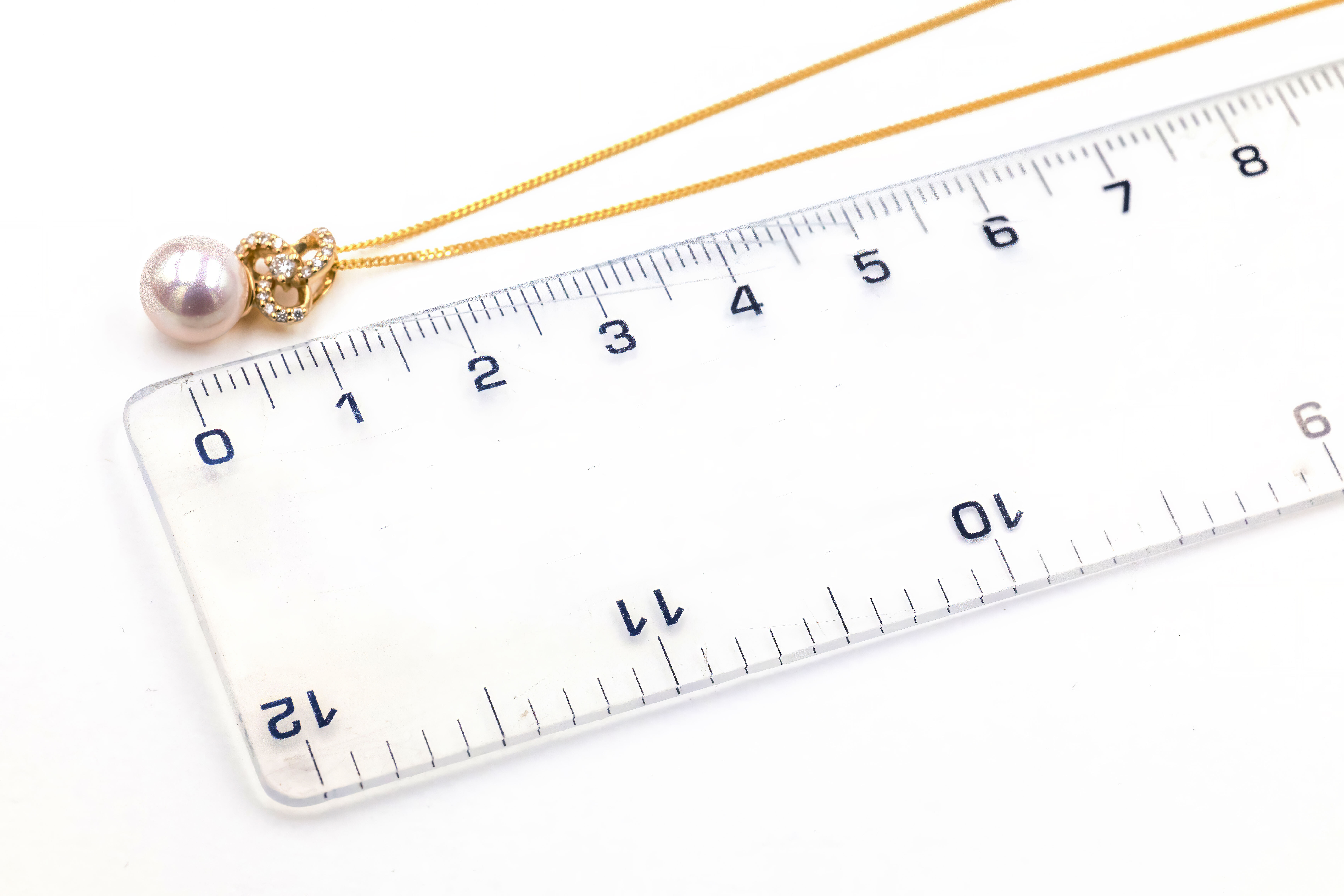 Gorgeous Yellow Gold Trinity Knot Necklace With a Polished Finish For Women. Picture For Scale.