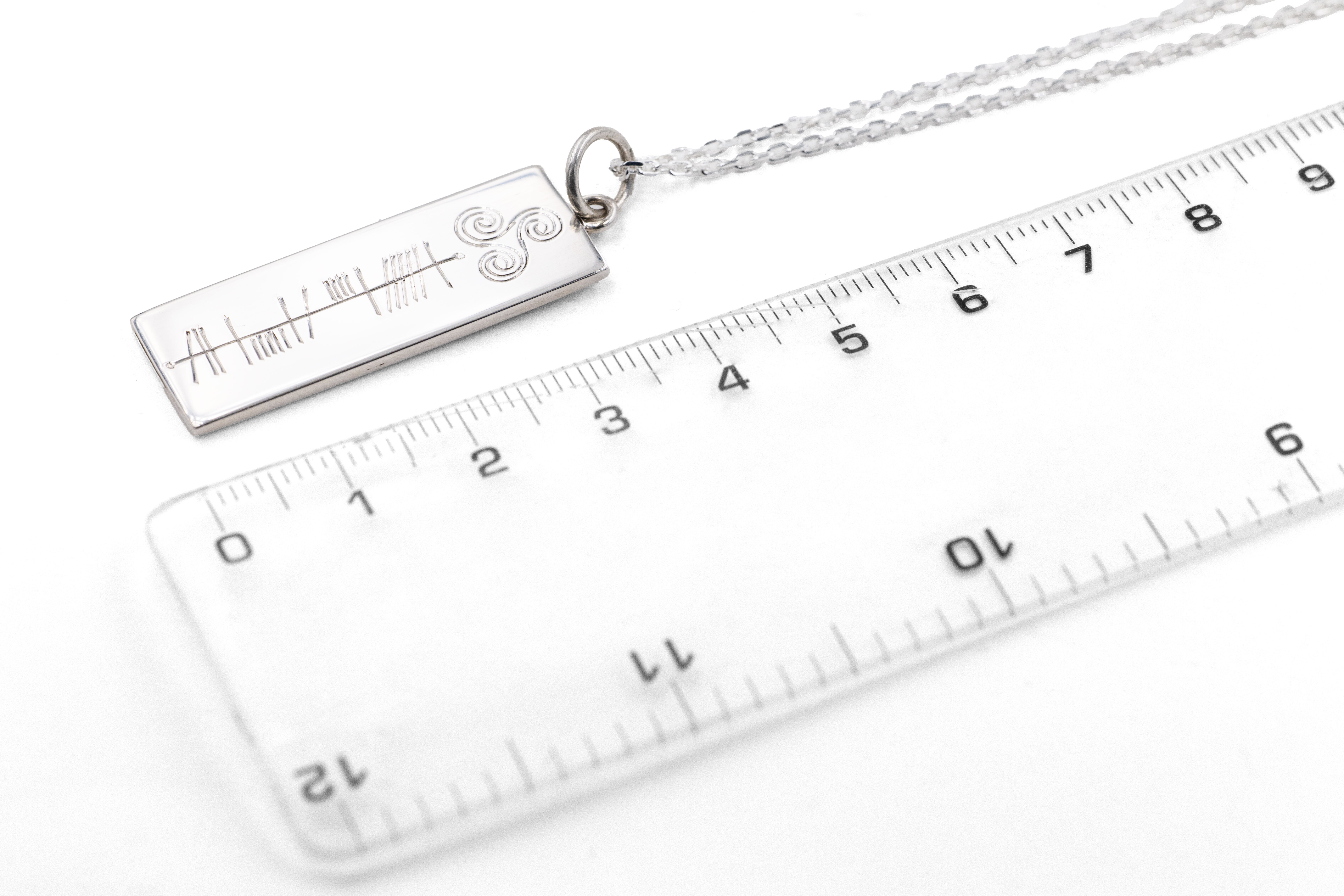 Engravable Sterling Silver Ogham & Triskele Necklace With a Polished Finish. Picture For Scale.