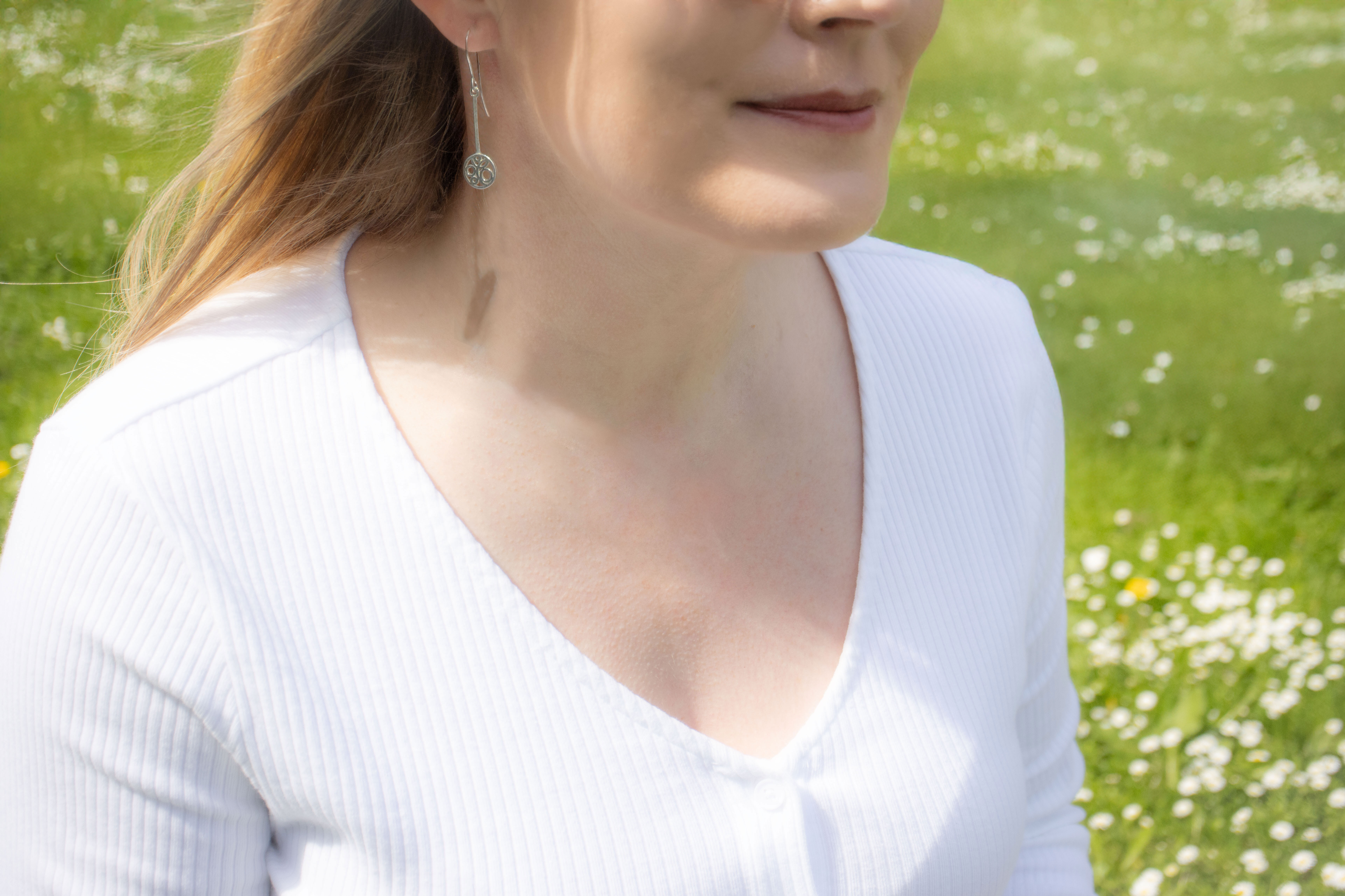 Attractive Sterling Silver Folklore & Newgrange Earrings For Women With a Polished Finish - Model Photo