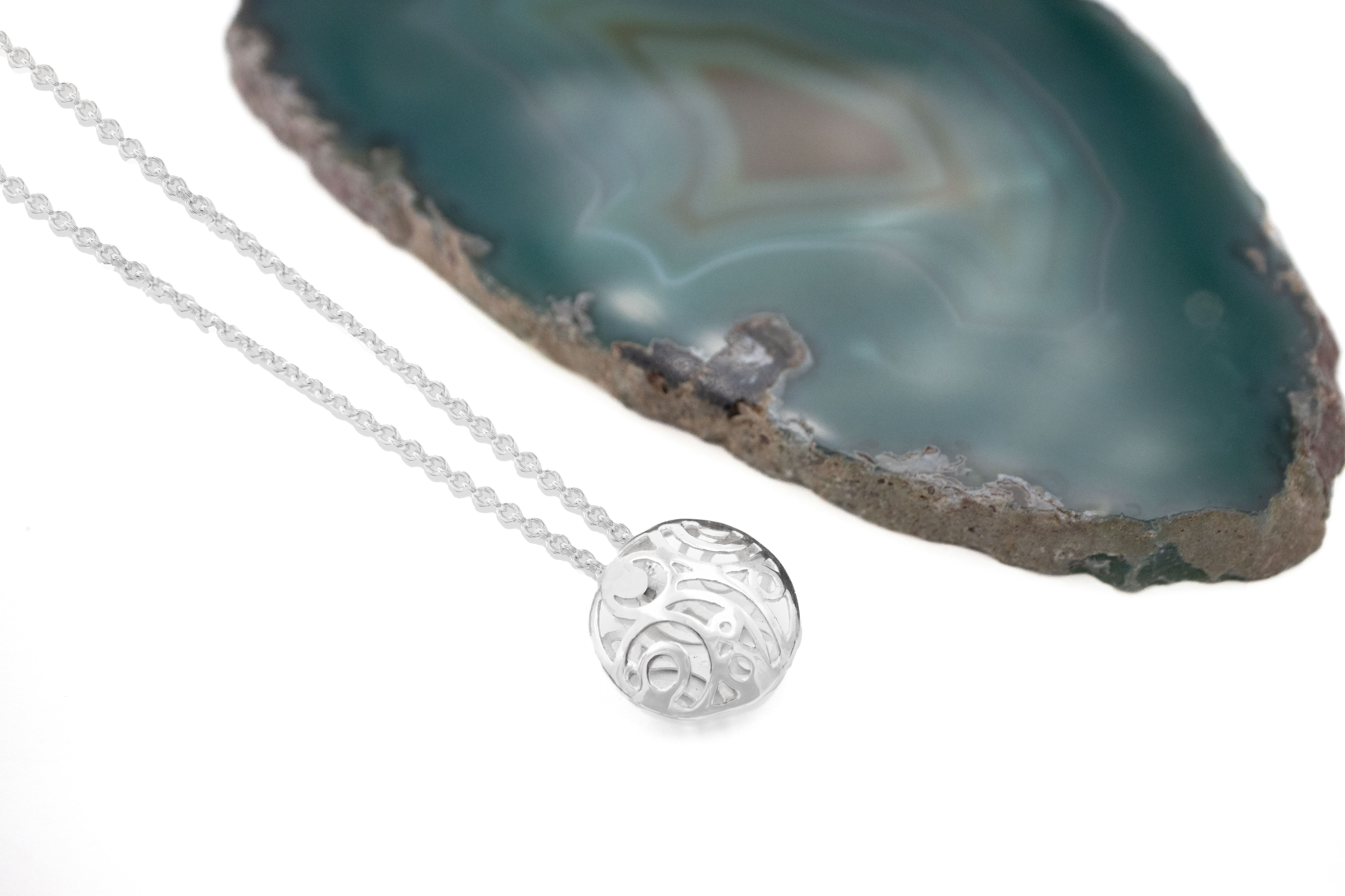 Real Sterling Silver Newgrange & Folklore Necklace With a Polished Finish For Women. Pictured Flat.