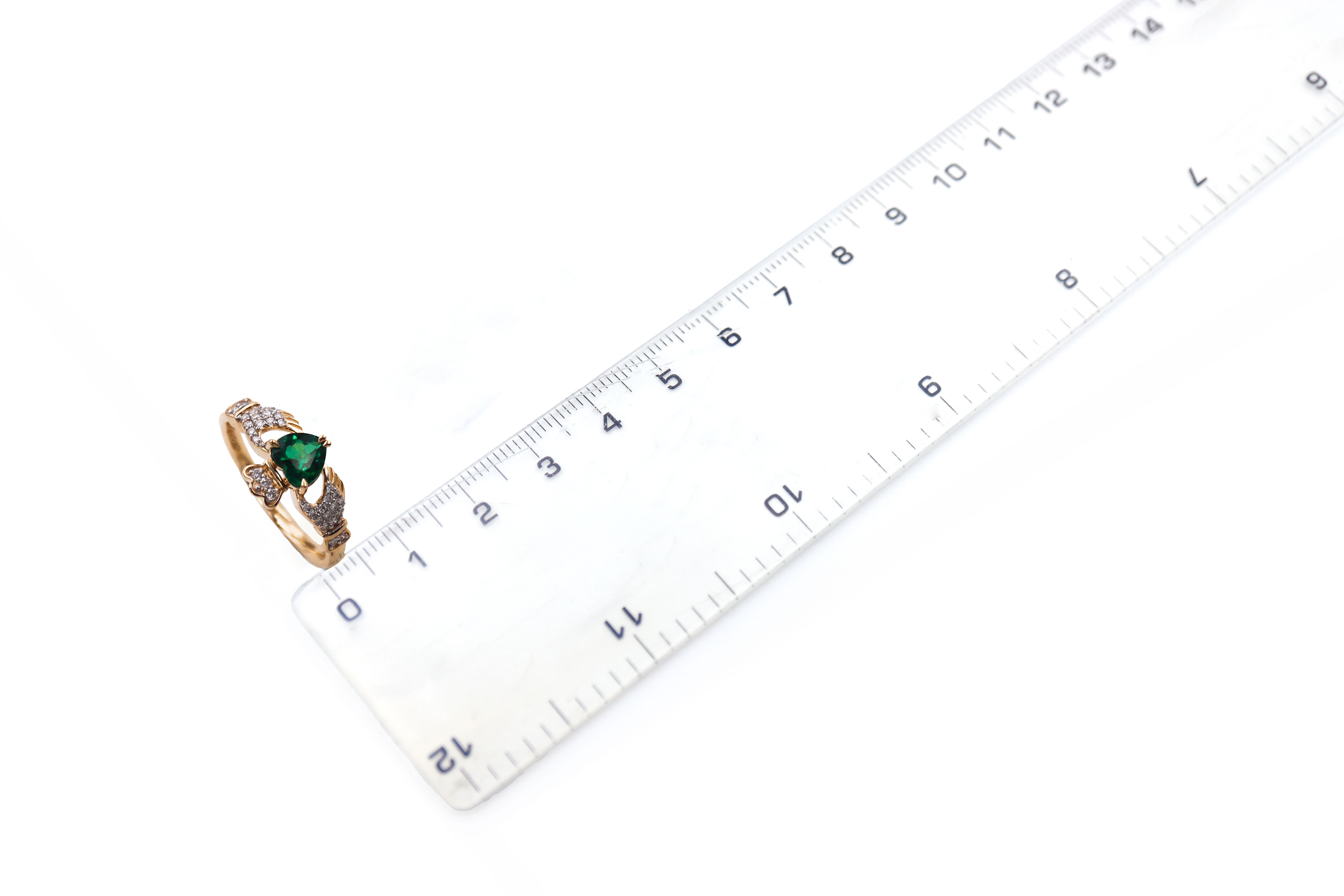 Romantic Yellow Gold Claddagh 0.70ct Lab Grown Emerald Engagement Ring For Women With a Polished Finish. Picture For Scale.