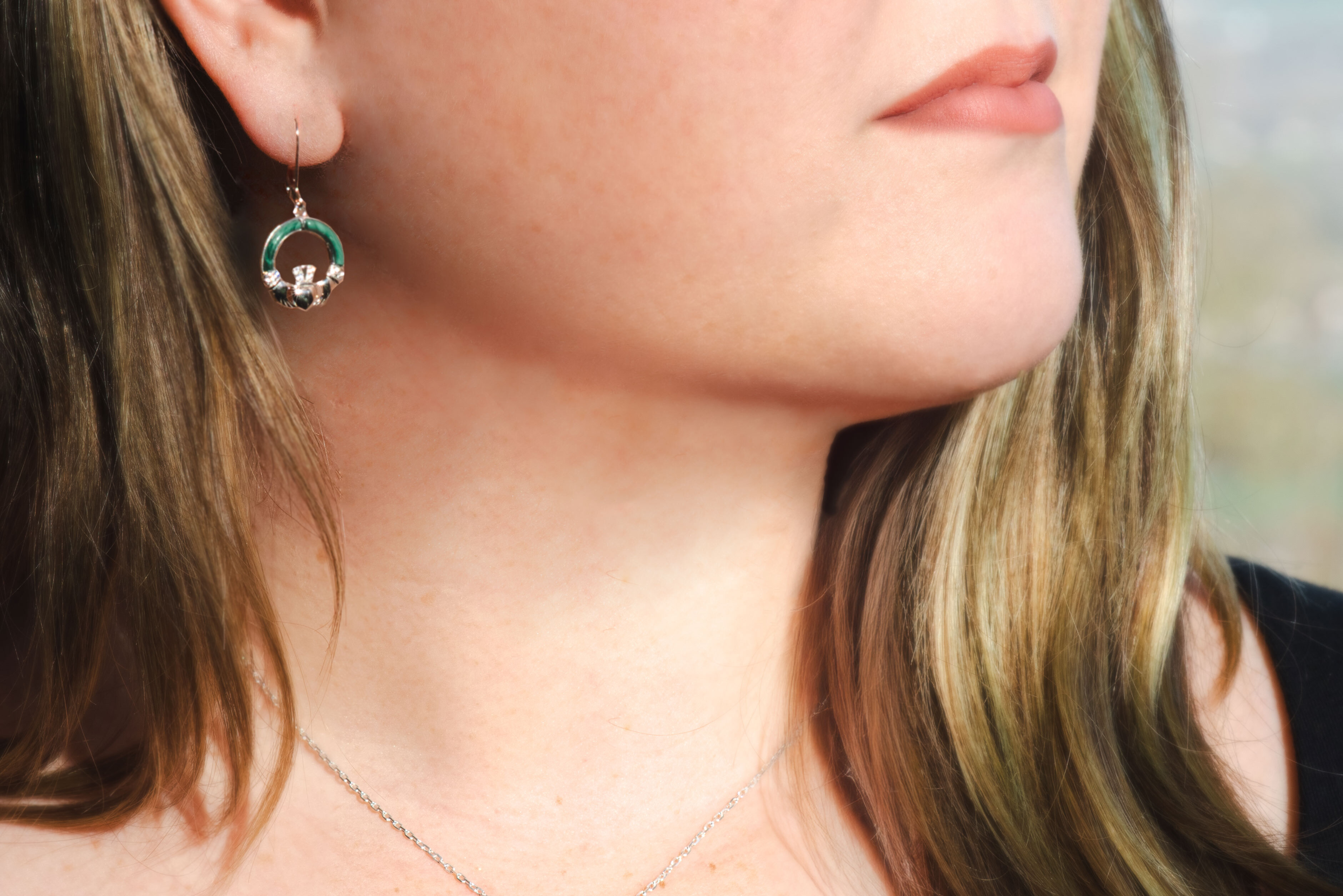 Attractive Sterling Silver Claddagh Earrings For Women With a Polished Finish - Model Photo