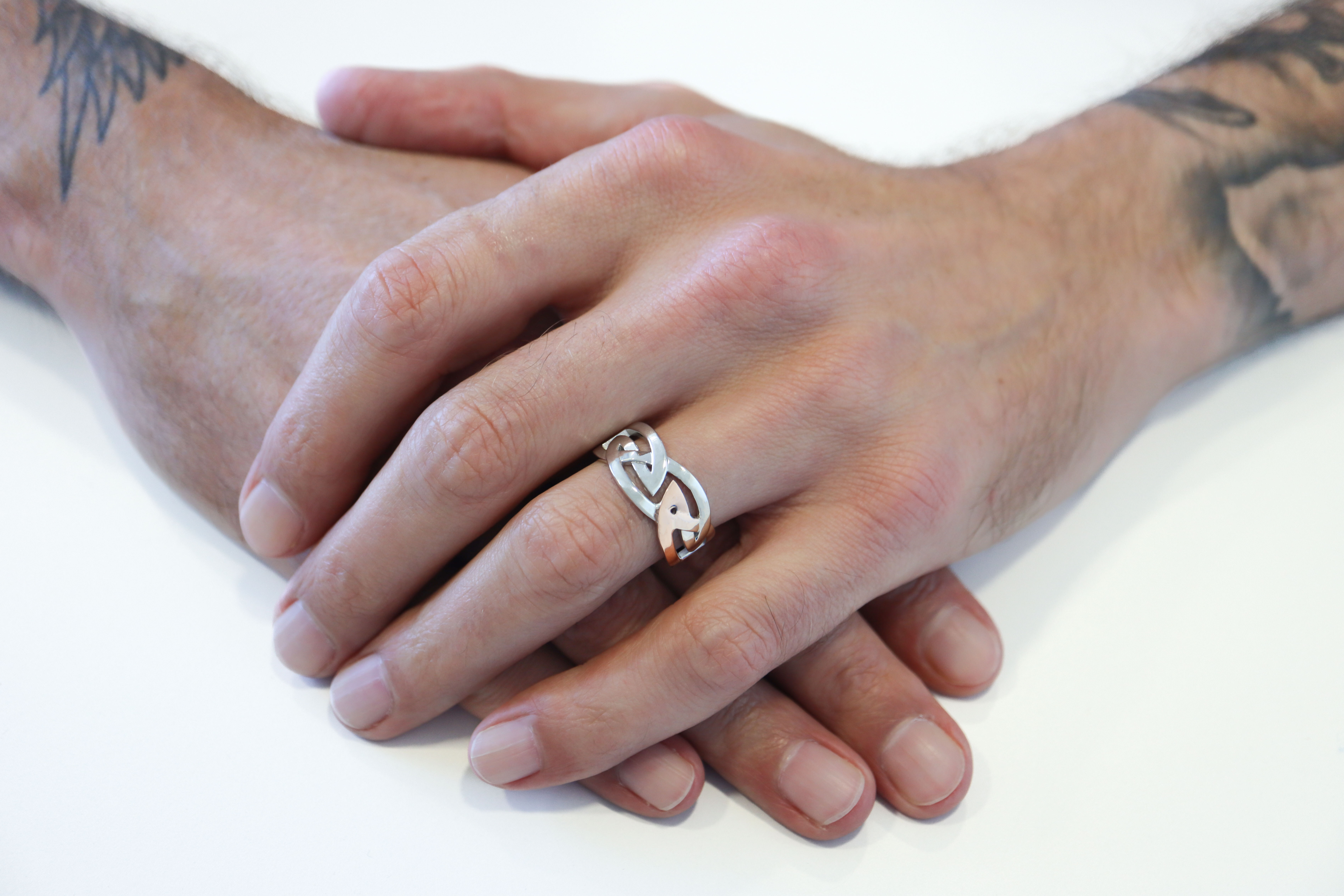 Traditional Sterling Silver & 10K Rose Gold Celtic Knot Ring With a Polished Finish For Men - Model Photo