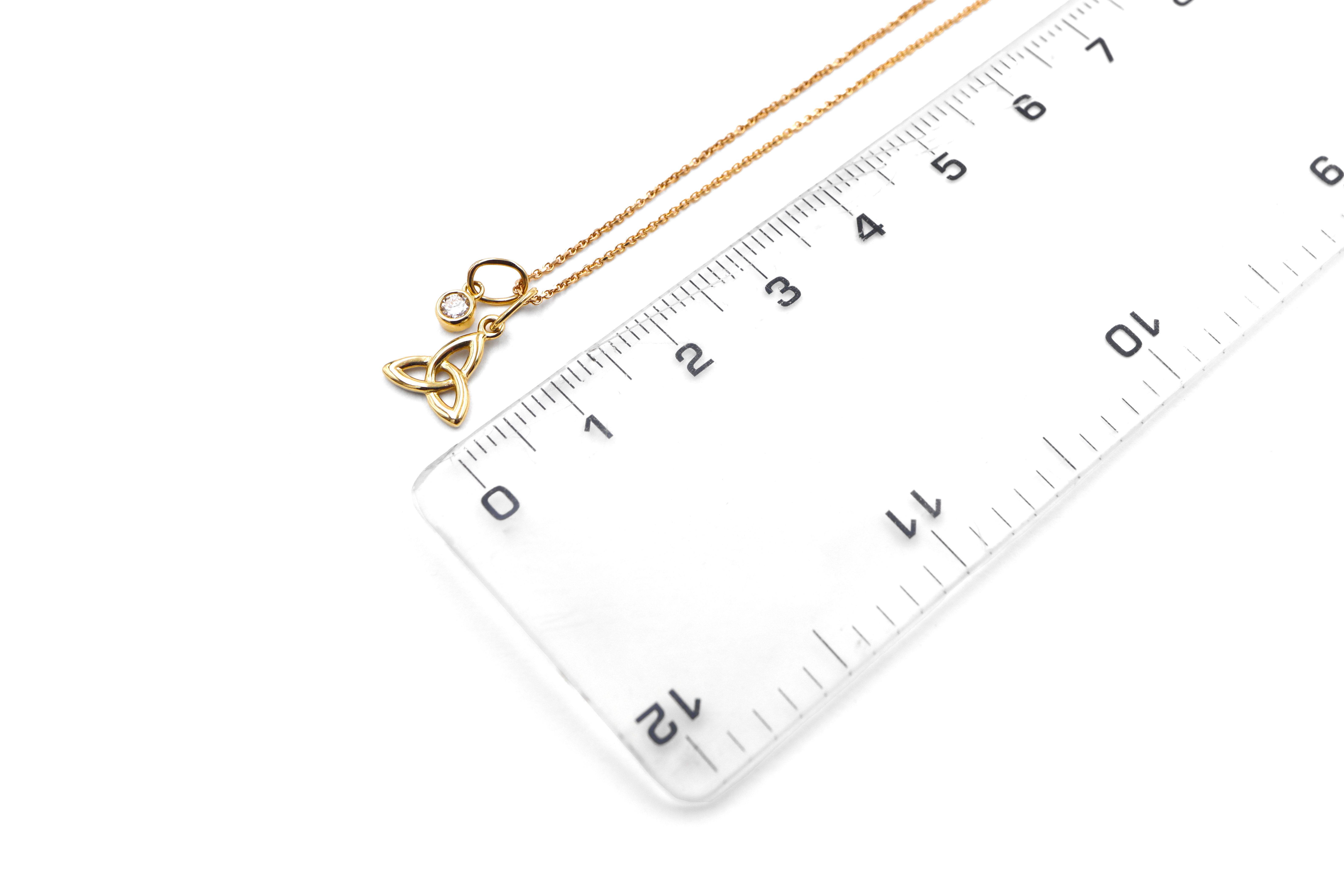 Gorgeous Yellow Gold Trinity Knot Necklace With a Polished Finish For Women. Picture For Scale.