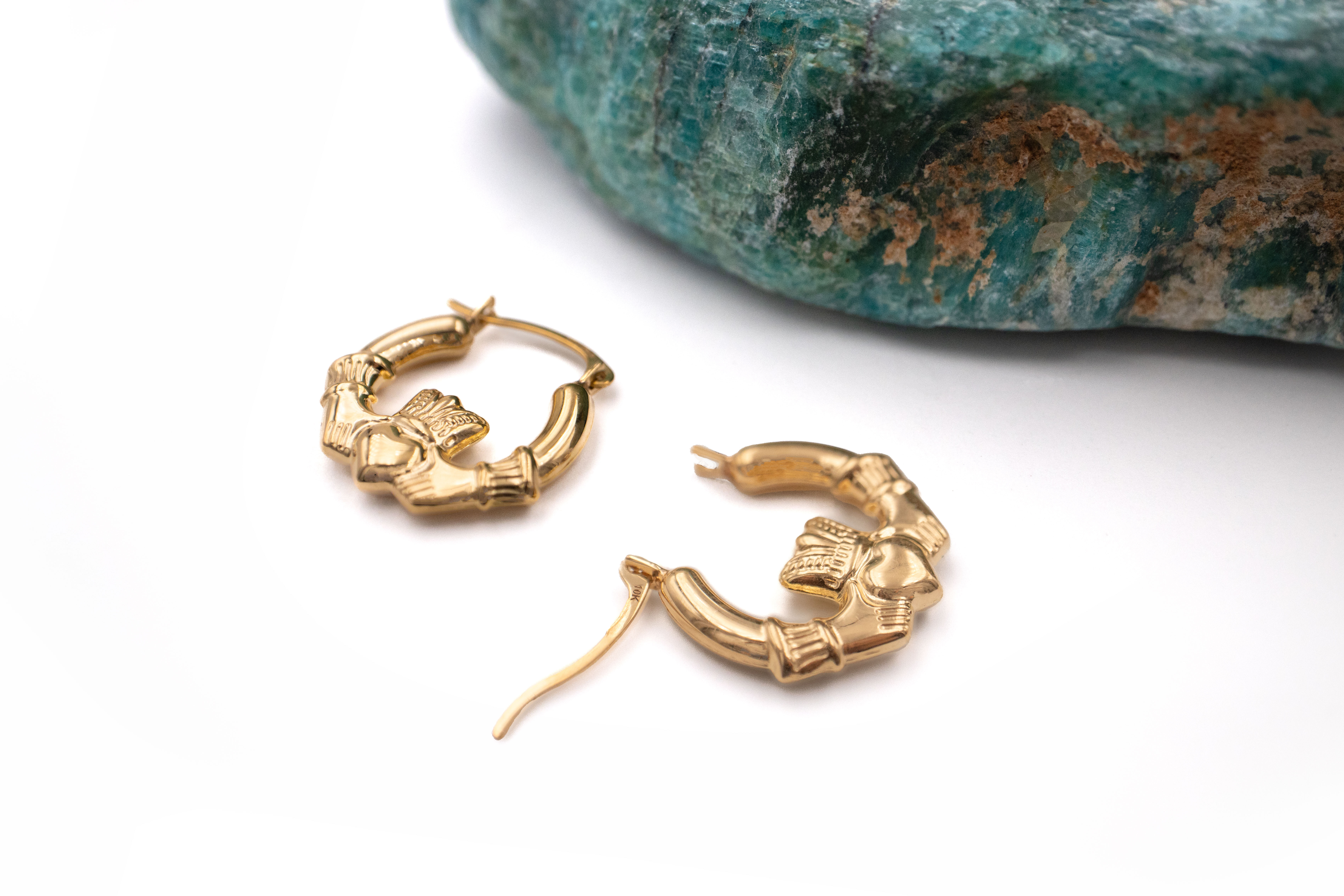 Small Womens Striking Polished 14K Yellow Gold Claddagh Earrings. Pictured Flat.