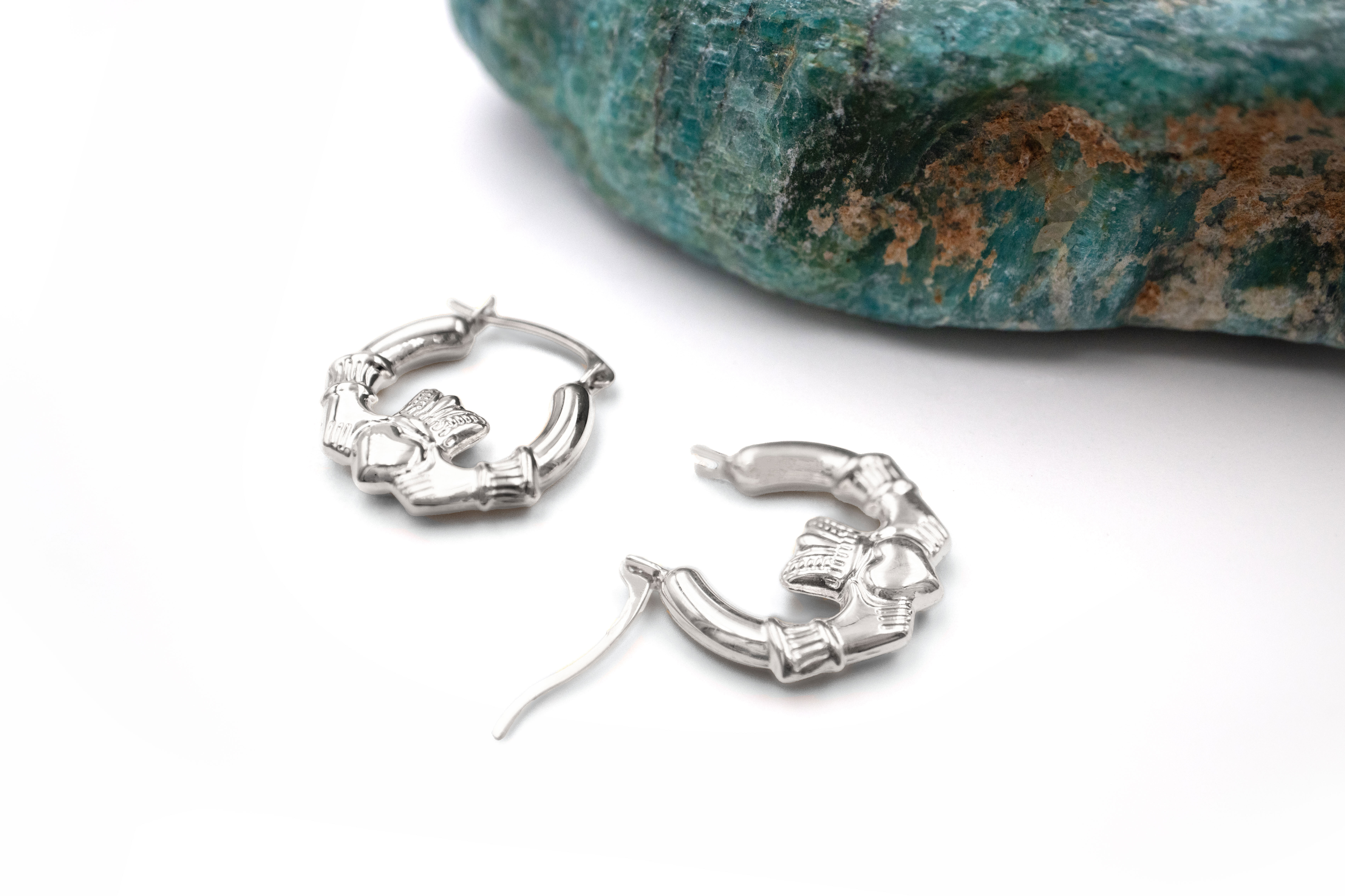 Small Striking Sterling Silver Claddagh Earrings For Women. Pictured Flat.