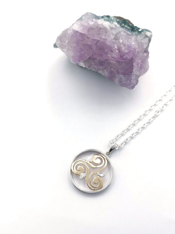 Womens Sterling Silver & 10K Yellow Gold Triskele & Newgrange Necklace. Pictured Flat.