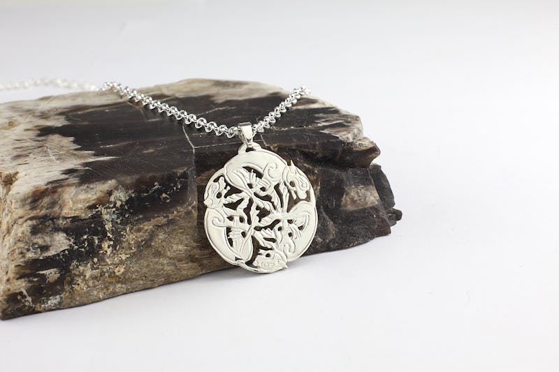 Womens Book of Kells & Triskele Necklace in Sterling Silver. Pictured Flat.